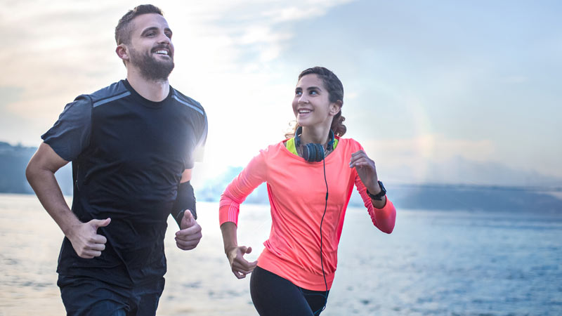 homem e mulher a correr ao ar livre